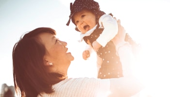 Woman holding baby aloft