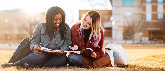 Students reading on a lawn