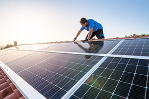 man_installing_solar_panels_on_roof_300x200